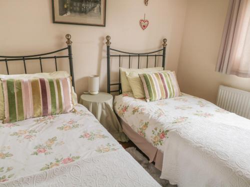 two beds sitting next to each other in a bedroom at Lower Cross in Keighley