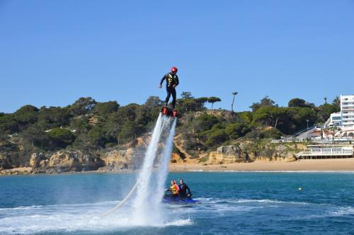 a person riding a water skis on top of a body of water at Apartamentos Carruna in Albufeira