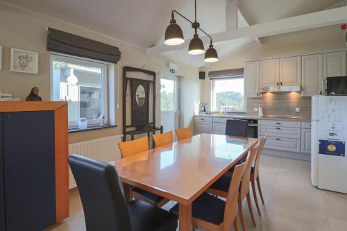 a kitchen with a wooden table and chairs at Vakantiewoning Tilia in Zottegem