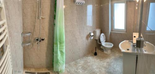 y baño con ducha, aseo y lavamanos. en Hostel JAZ, en Bucarest
