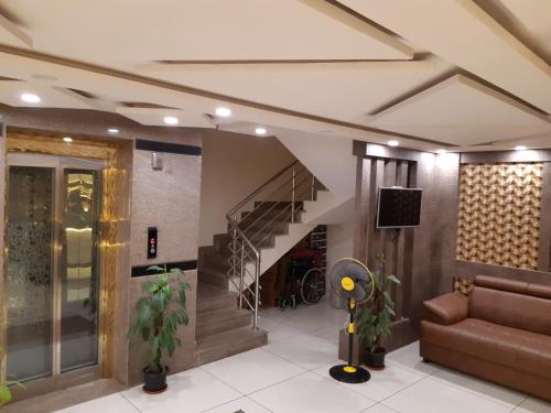 a living room with a staircase and a couch at SAHARA Inn in Bangalore