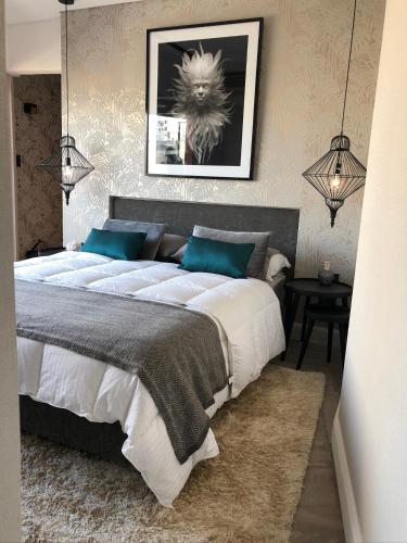 a bedroom with a large bed with blue pillows at GATE Recoleta in Buenos Aires