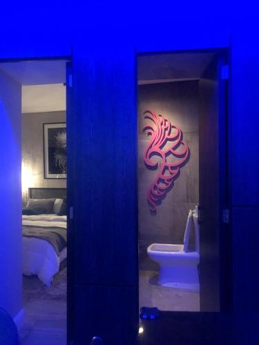 a blue room with a bedroom with a bed and a sign at GATE Recoleta in Buenos Aires