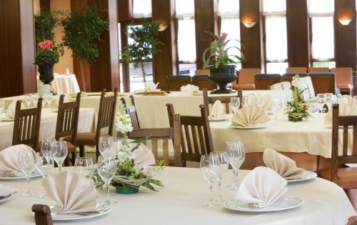 a dining room with tables with white tablecloths and flowers at Hotel Txartel in Lasarte