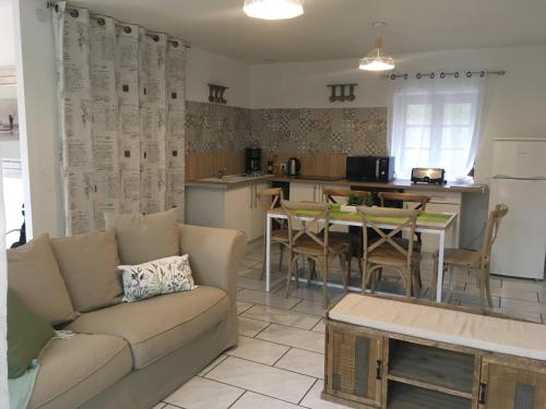 a living room with a couch and a table and a kitchen at Aparthotel Des 2 Caps in Ambleteuse