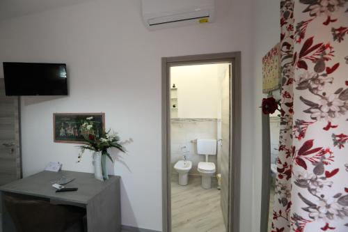 łazienka z toaletą, umywalką i drzwiami w obiekcie B&B ANGELO w mieście Caltanissetta