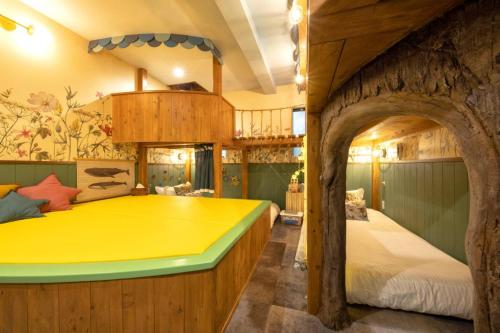 een slaapkamer met een groot geel bed in een boomhut bij Holy House in Tokyo