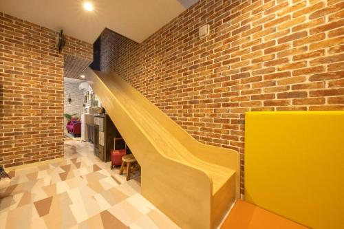 a yellow staircase in a brick wall at Holy House in Tokyo