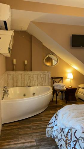 a large white tub in a room with a bed at Apartamentos A Poniente in Villanueva de la Concepción