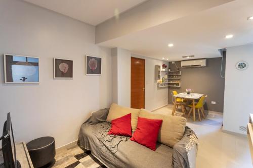 a living room with a couch with red pillows at Departamento Tucuman in San Miguel de Tucumán