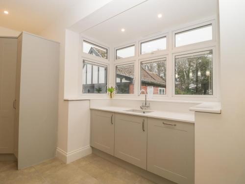 a kitchen with a sink and two windows at Greenlawns in Burnham on Sea