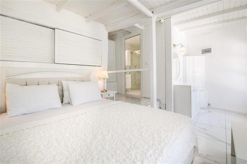 a white bedroom with a white bed and a window at Club Çapa Hotel in Kas