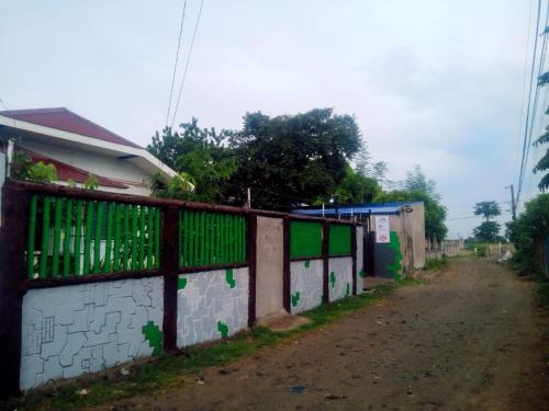 an alley with a fence next to a building at Innskeep in Calingcuan