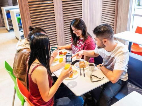 a group of people sitting at a table eating food at ibis budget Sao Caetano in São Caetano do Sul