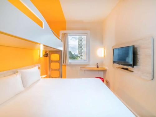a bedroom with a white bed and a tv at ibis budget Sao Caetano in São Caetano do Sul
