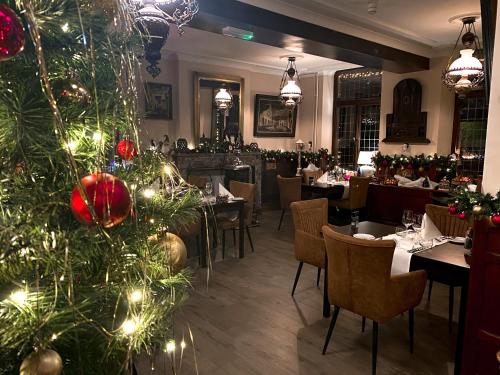 a christmas tree in the dining room of a restaurant at Hotel Crasborn Thorn in Thorn