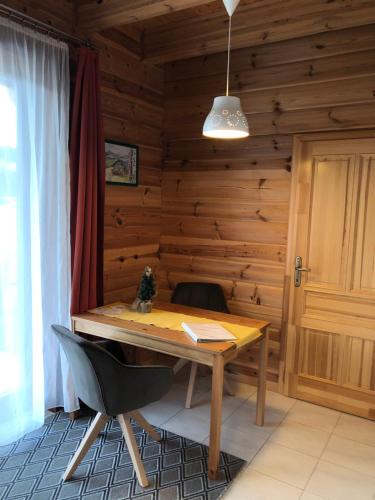 Haus Edelgrün في توبليتز: غرفة خشبية مع طاولة خشبية وكرسي