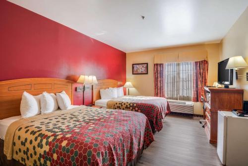 Cette chambre comprend deux lits et une télévision. dans l'établissement Econo Lodge Lubbock I-27, à Lubbock