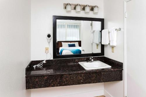 a bathroom with a sink and a mirror at Clarion Inn Surfrider Resort in Depoe Bay
