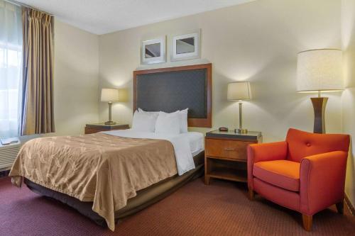 a hotel room with a bed and a chair at Quality Inn & Suites Lakewood - Denver Southwest in Lakewood