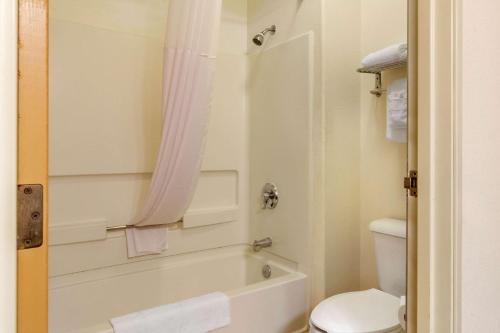 uma casa de banho com uma banheira branca e um WC. em Quality Inn & Suites Lakewood - Denver Southwest em Lakewood