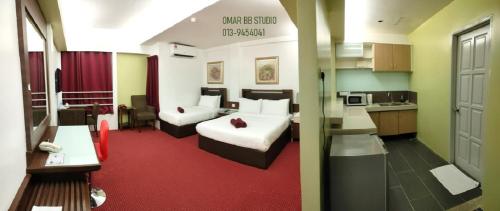 una camera d'albergo con due letti e una cucina di OMAR BB STUDIO a Kota Bharu