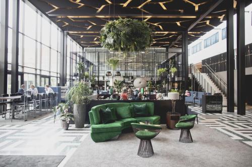 a lobby with a green couch and plants at Hotel Skt Petri in Copenhagen