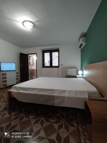 a bedroom with a large bed and a flat screen tv at Appartamento Via Filippini in Reggio di Calabria