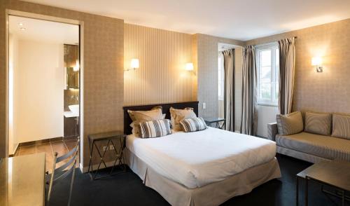 Un pat sau paturi într-o cameră la Logis - Hôtel & Restaurant du Tribunal