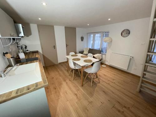 a kitchen and living room with a table and chairs at Logements équipés à Onnaing avec espace Balneo en OPTION proche Toyota, autoroute et Valenciennes in Onnaing
