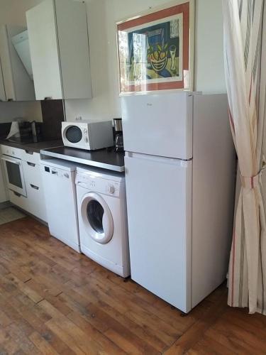Il comprend une cuisine équipée d'un réfrigérateur blanc et d'un lave-linge. dans l'établissement Plage et centre, à Villers-sur-Mer