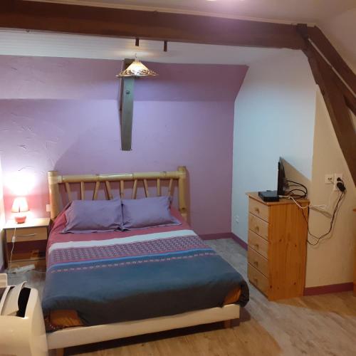 - une chambre avec un lit aux murs violets et une lampe dans l'établissement chez vous chez nous, à Antigny