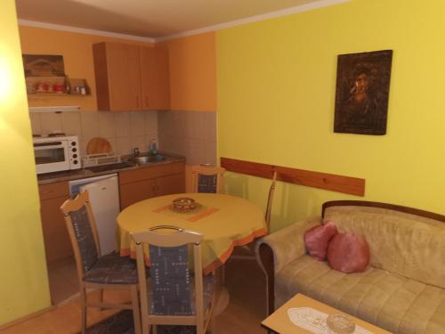 卡路耶斯科巴雷的住宿－Apartmani Popovic，厨房以及带桌子和沙发的客厅。