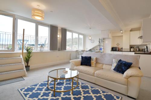 a living room with a couch and a table at Superb Scarborough Penthouse with Balcony, lift, parking, views in Scarborough