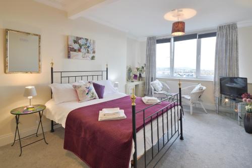 a bedroom with a bed and a tv in it at Scarborough-Penthouse, with private balcony, lift and parking in Scarborough