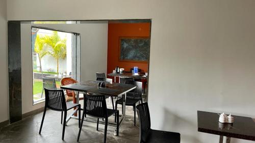 jadalnia ze stołami i krzesłami oraz oknem w obiekcie HOTEL FRIDAY INN w mieście Yercaud