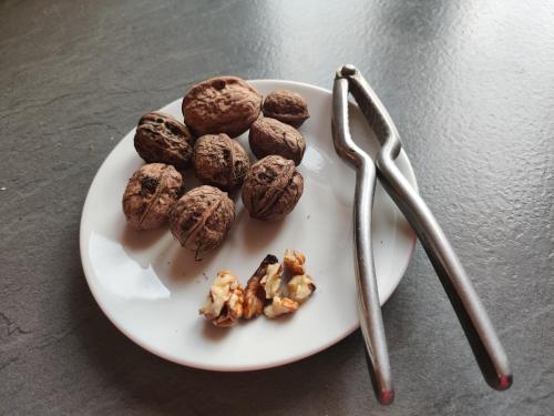 a white plate with nuts and two utensils at Casa Martin , 4 bedroom villa in Bisenti