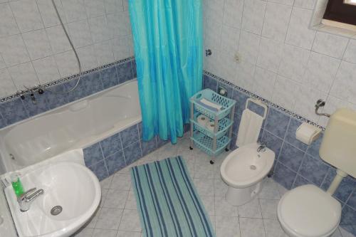a bathroom with a toilet and a tub and a sink at Oaza duplex in Dubrovnik
