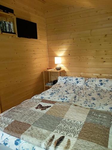 a bedroom with a bed with a quilt on it at Bakkakot 2 - Cozy Cabins in the Woods in Akureyri