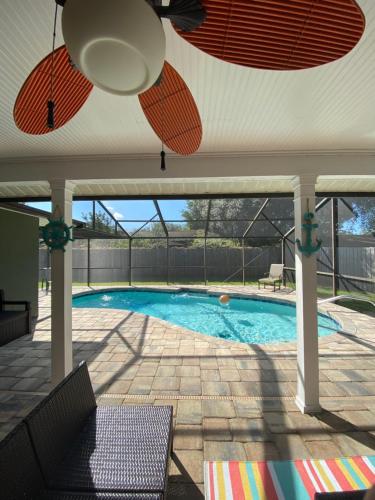 een zwembad met een plafondventilator bij 3 bedrooms house with private, heated pool 8 miles to Siesta Key Beach, in Sarasota