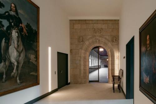 a hallway with paintings of horses on the walls at Parador de Turismo de León in León