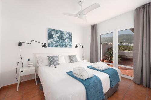 1 dormitorio blanco con 2 camas y ventana en Superior H - AD Alberto Dorner en Icod de los Vinos