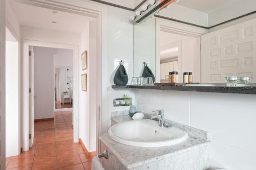 uma casa de banho branca com um lavatório e um espelho em Superior H - AD Alberto Dorner em Icod de los Vinos
