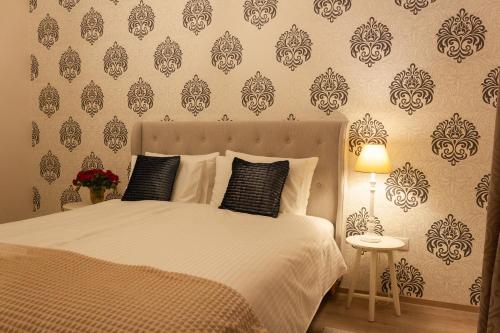 a bedroom with a bed with black and white wallpaper at Cozy Family Apartments in Braşov