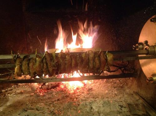 uma fila de comida a cozinhar numa grelha numa lareira em Hotel Ristorante Da Roverino em Comunanza