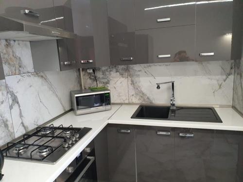 a kitchen with a stove and a microwave at MONAR City center apartment free parking in Košice