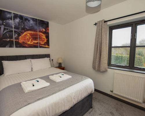 a bedroom with a bed with two towels on it at Spring & Haven in Conwy