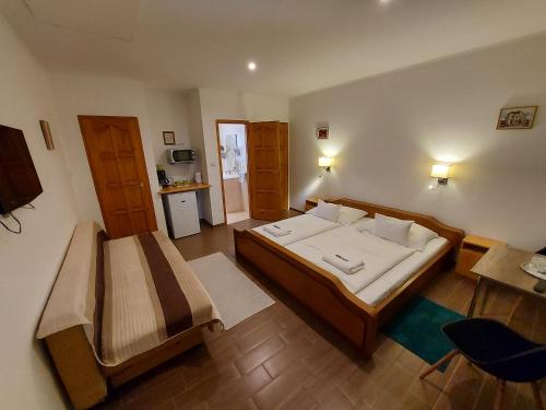 1 dormitorio con cama, escritorio y mesa en Böne Vendégház és Borozó en Tokaj