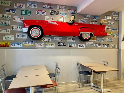 a red car on the wall of a room with tables at Aston Hotel in Andorra la Vella