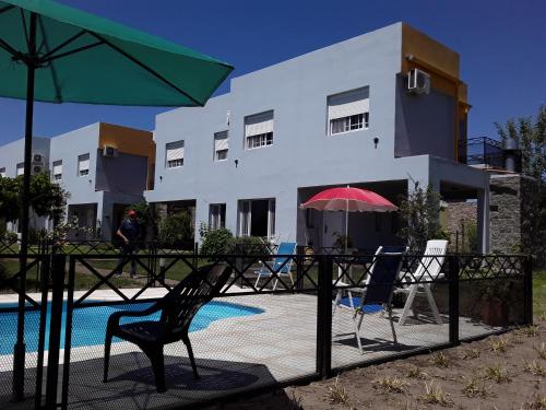 a house with a pool and two chairs and an umbrella at Irundy Apartments in Federación